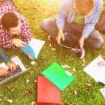 An aerial view is showing a group of college students studying on the grass.