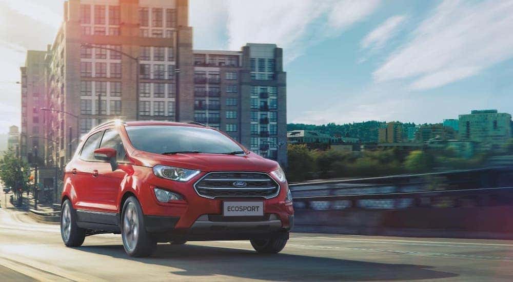 A red 2020 Ford Ecosport is driving away from a city after leaving a Ford SUV dealer in Cincinnati.