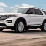 A white 2021 Ford Explorer King Ranch is driving on a dirt road after leaving a Cincinnati Ford Explorer dealer.