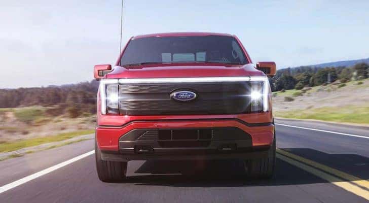 A red 2022 Ford Lightning is shown from the front after leaving a Ford Lightning dealership.