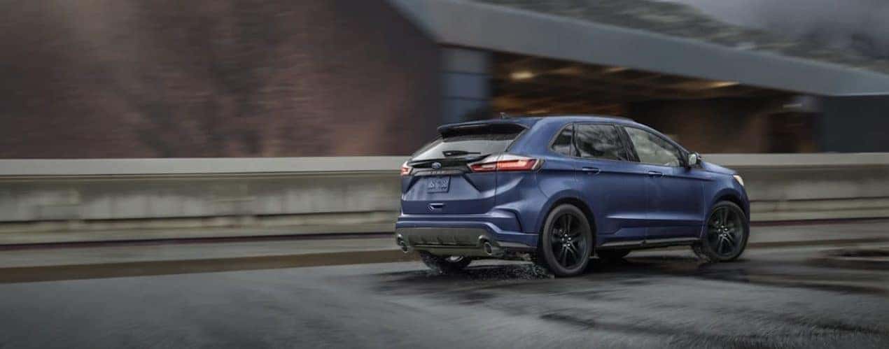 A blue 2022 Ford Edge is shown from the side driving on an open road.