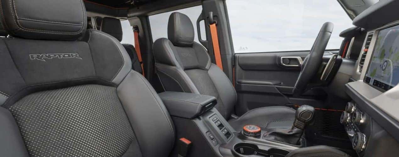The grey interior of a 2022 Ford Bronco Raptor shows the front seats.