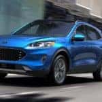 A blue 2020 Ford Escape is shown from the front driving through a city after searching for a used Ford for sale.