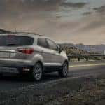 A silver 2021 Ford EcoSport is shown from the rear driving on an open road after leaving a Beckett Ridge Ford dealership.