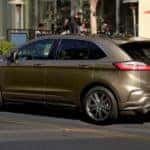 A brown 2019 Ford Edge is shown parked on the side of a city street.