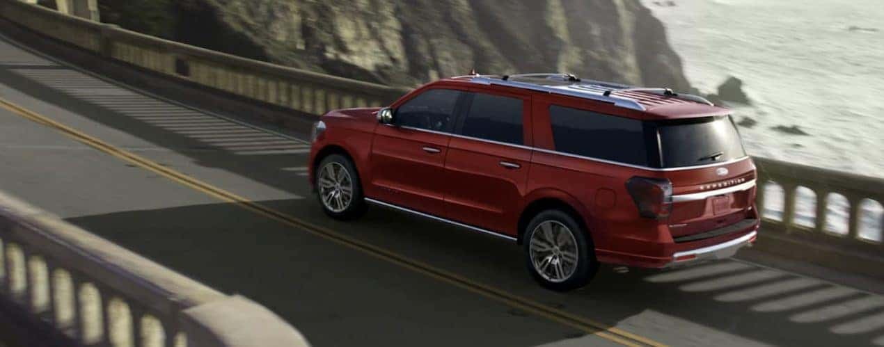 A red 2023 Ford Expedition is shown driving over a bridge.