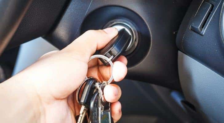A close up shows a set of car keys in an ignition.
