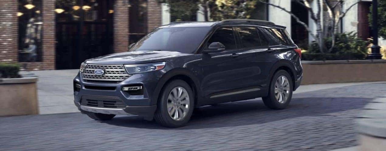 A blue 2023 Ford Explorer is shown driving from the side.