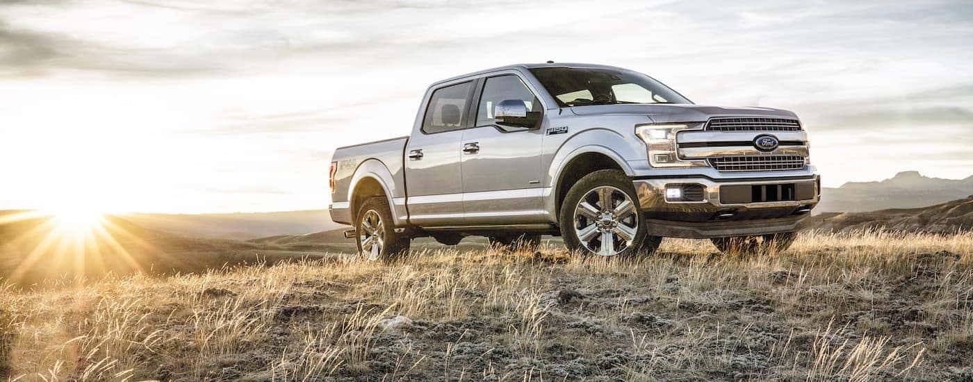 A silver 2018 Ford F-150 for sale is shown parked on a field.