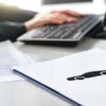A set of paperwork is shown on a desk after researching how to 'value my trade.'