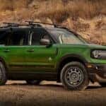 A green 2023 Ford Bronco Sport Outer Banks is shown parked off-road.