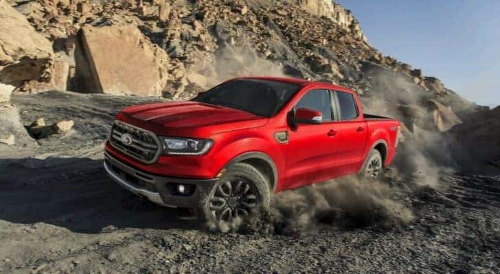 A red 2023 Ford Ranger FX4 is shown kicking up dust.