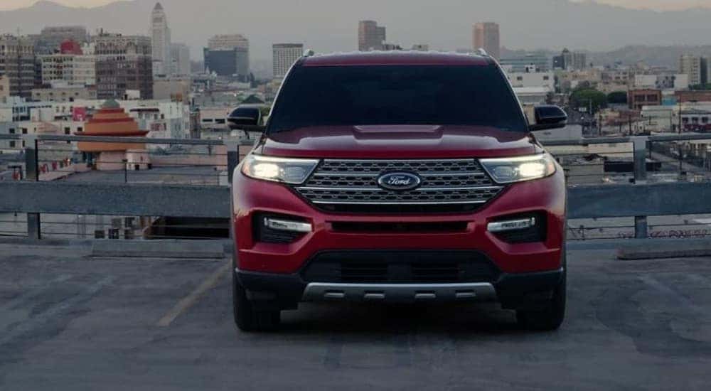 A red 2023 Ford Explorer Limited Hybrid is shown parked near a city.