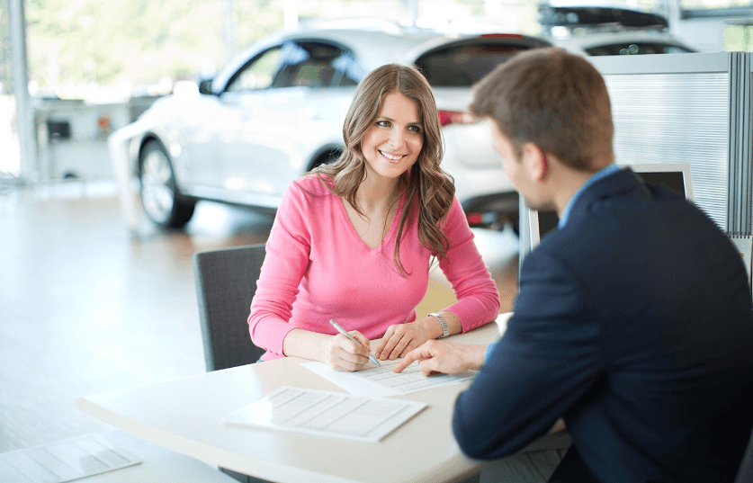 Woman and salesman in Kings Ford Inc signing for a new vehicle