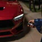 A popular Ford in Cincinnati, a red 2024 Ford Mustang, is shown being parked in garage.
