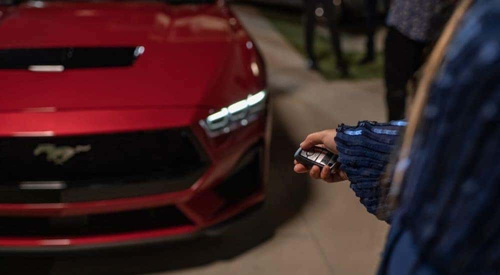 A popular Ford in Cincinnati, a red 2024 Ford Mustang, is shown being parked in garage.