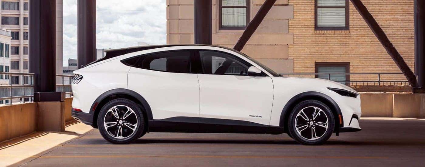 One of the most popular Ford EVs, a white 2021 Ford Mustang Mach-E, is shown in a parking garage.