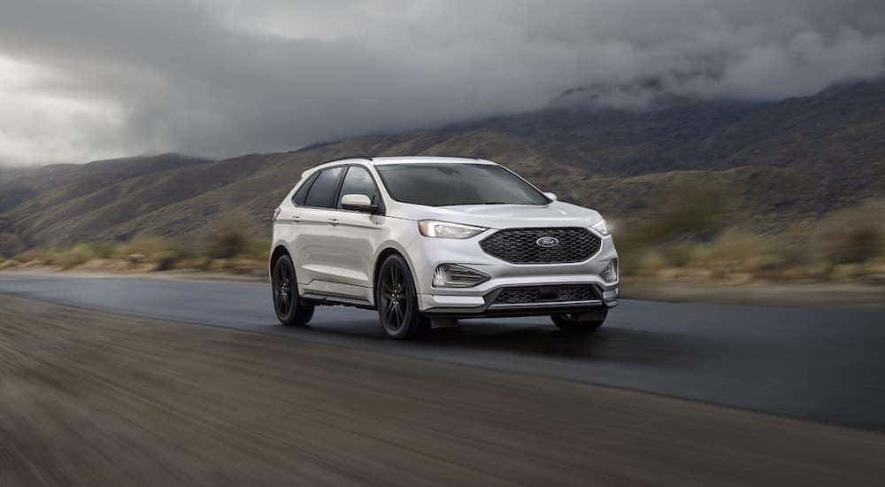 A white 2024 Ford Edge driving on a misty road.