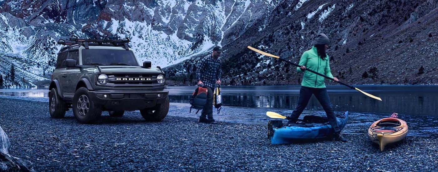 A grey 2024 Ford Bronco Big Bend parked next to a river with kayakers.