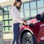 A red 2024 Ford Escape Plug-in Hybrid is shown being charged.