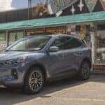 A gray 2025 Ford Escape PHEV is shown parked near a store.