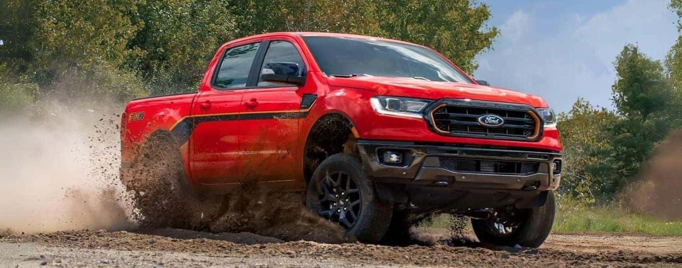 A red 2023 Ford Ranger Splash FX4 is shown kicking up dust off-road.