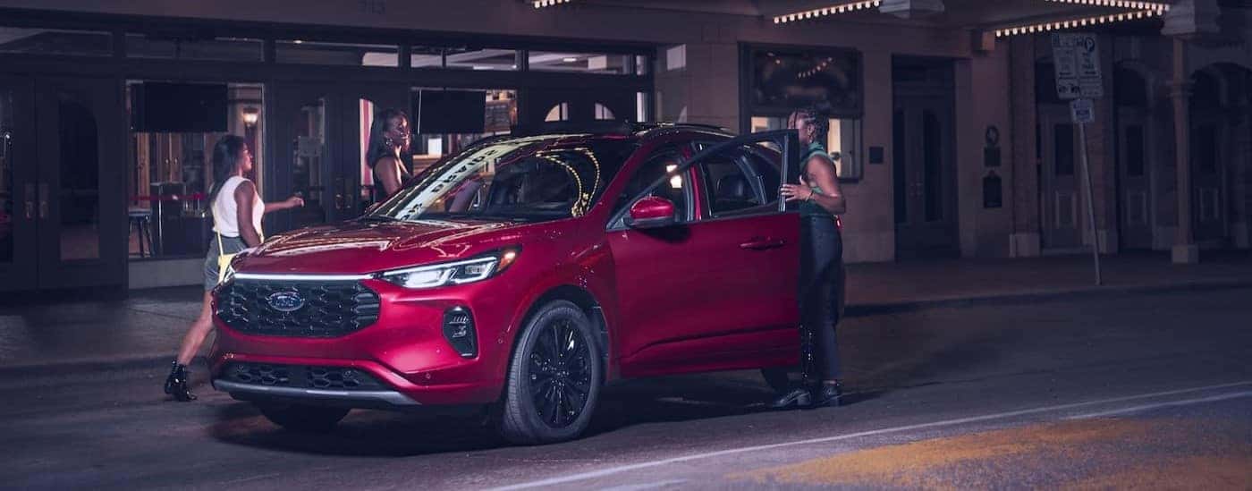 A red 2024 Ford Escape is shown parked near a theater.
