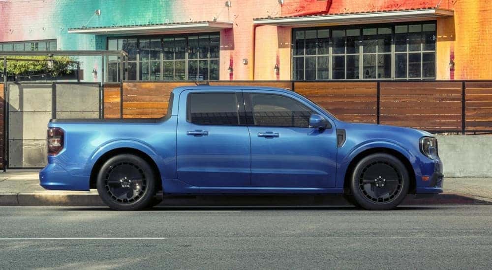 A blue 2025 Ford Maverick Lobo is shown in front of a colorful building.