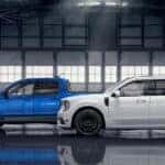 A blue 2025 Ford Maverick Tremor and white Maverick Lobo are shown in a warehouse.