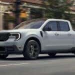 A grey 2025 Ford Maverick is shown driving to a Ford dealer near West Chester.