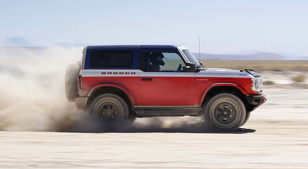 Side view of a red 2025 Ford Bronco Stroppe Edition racing through sand.