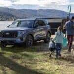 A family with camping gear next to a blue 2025 Ford Explorer.