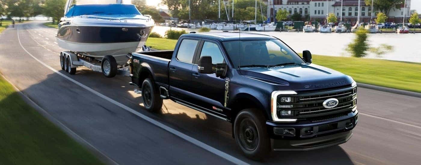 A black 2025 Ford F-350 towing a boat.