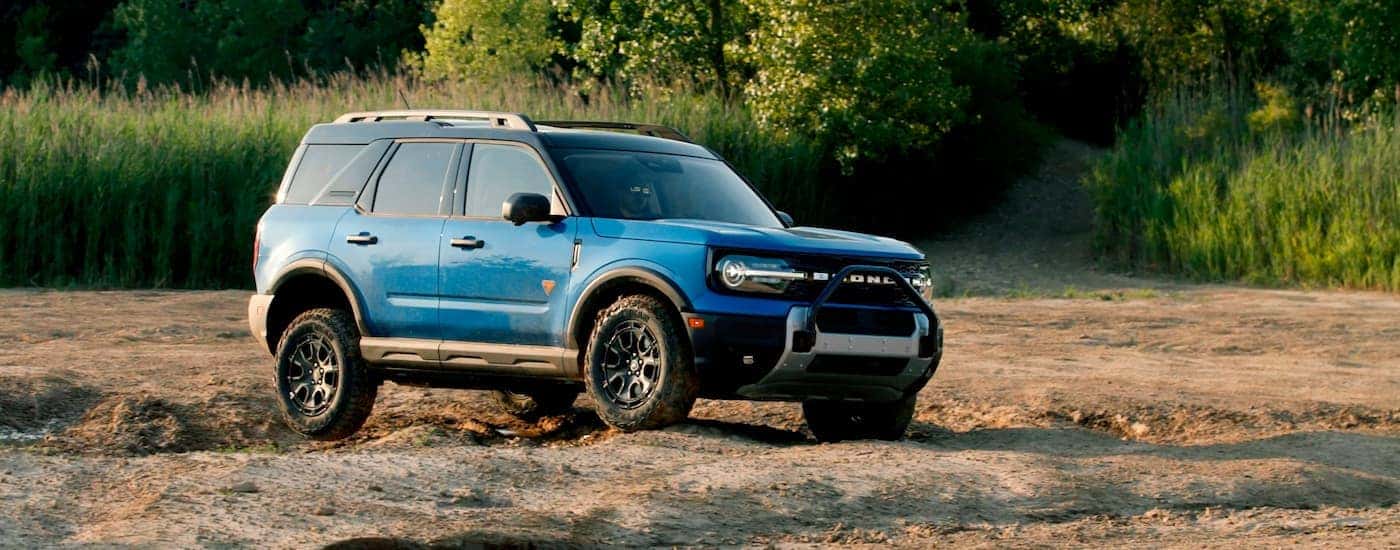 Blue 2025 Ford Bronco Sport Badlands driving on dirt.