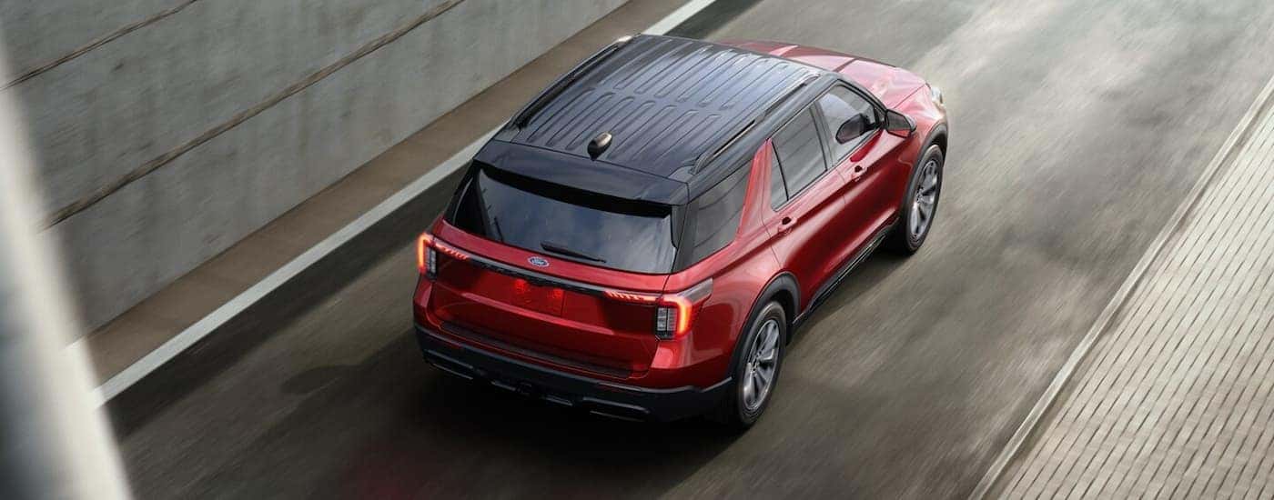 Red 2025 Ford Explorer driving on a highway to a Ford dealer near Hyde Park.