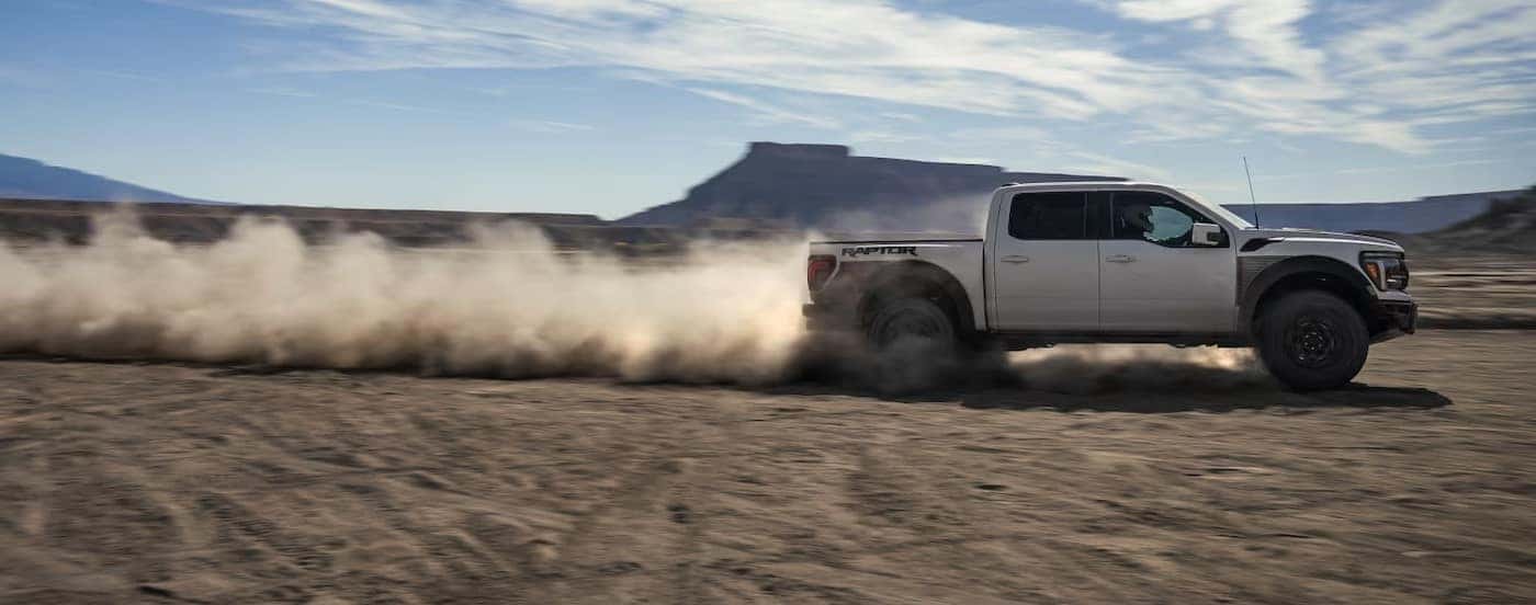 A white 2025 Ford F-150 Raptor off-roading.