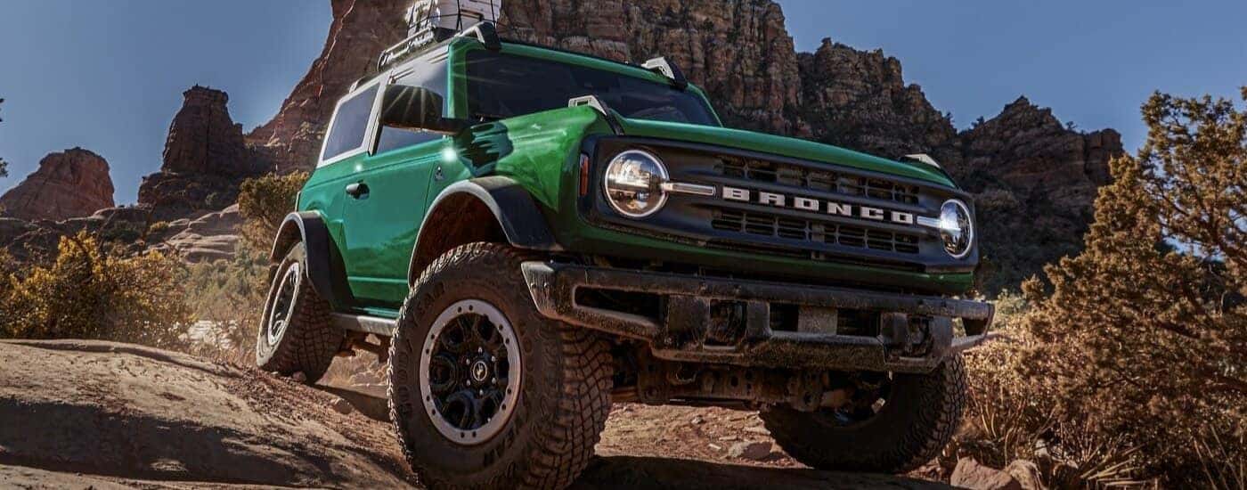 Green 2025 Ford Bronco Outer Banks for sale near Milford driving down a hill.