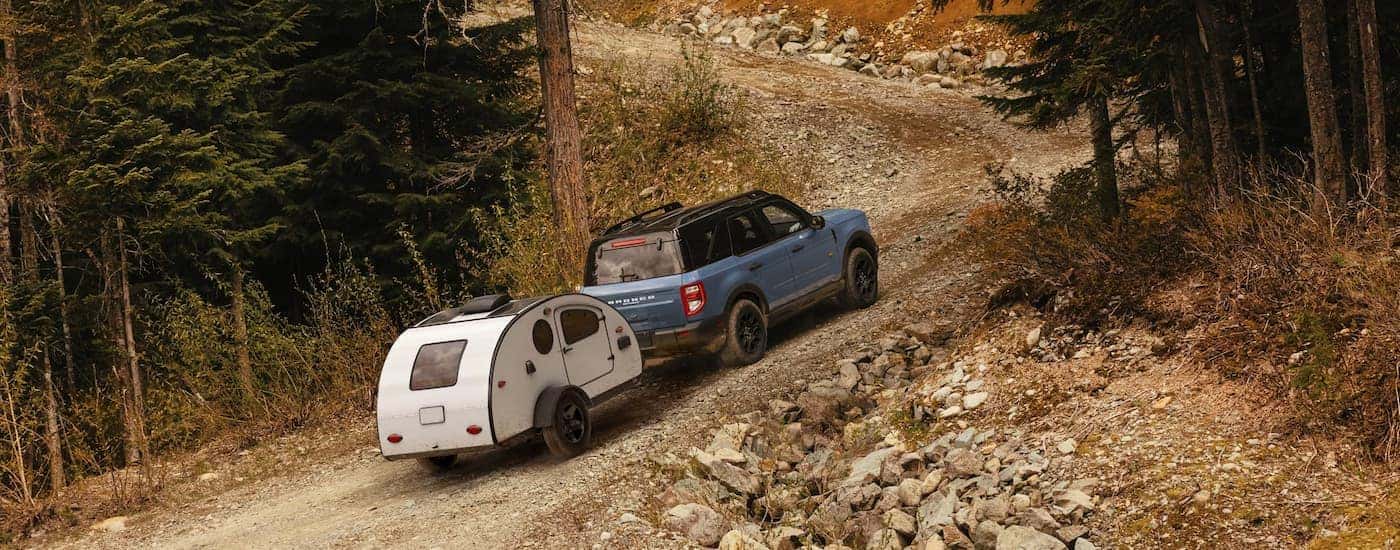 A blue 2025 Ford Bronco Sport towing a camper