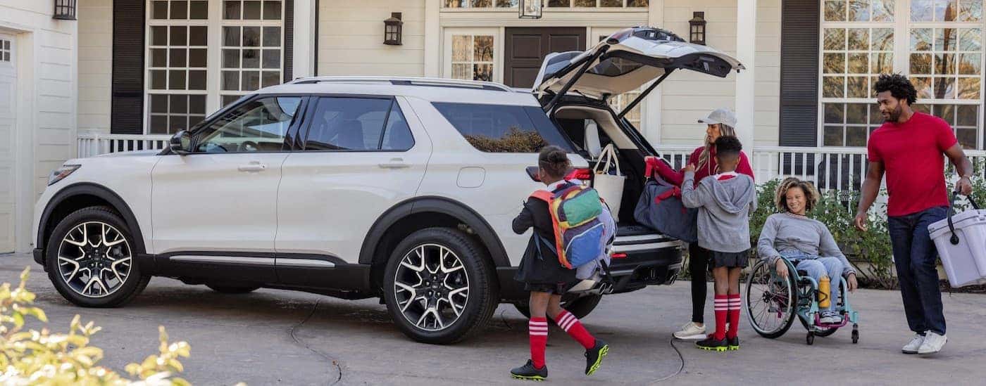 A white 2025 Ford Explorer parked near a family.
