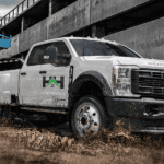 White 2026 Ford F-350 towing a utility vehicle