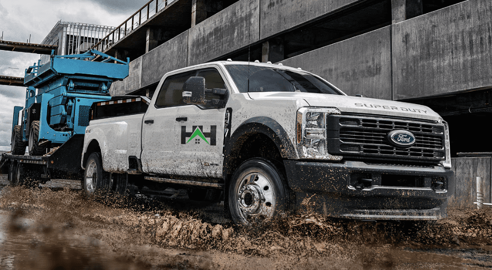 White 2026 Ford F-350 towing a utility vehicle