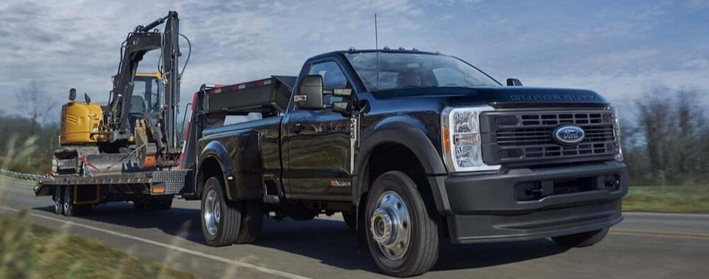 A black 2025 Ford F-450 towing a trailer.