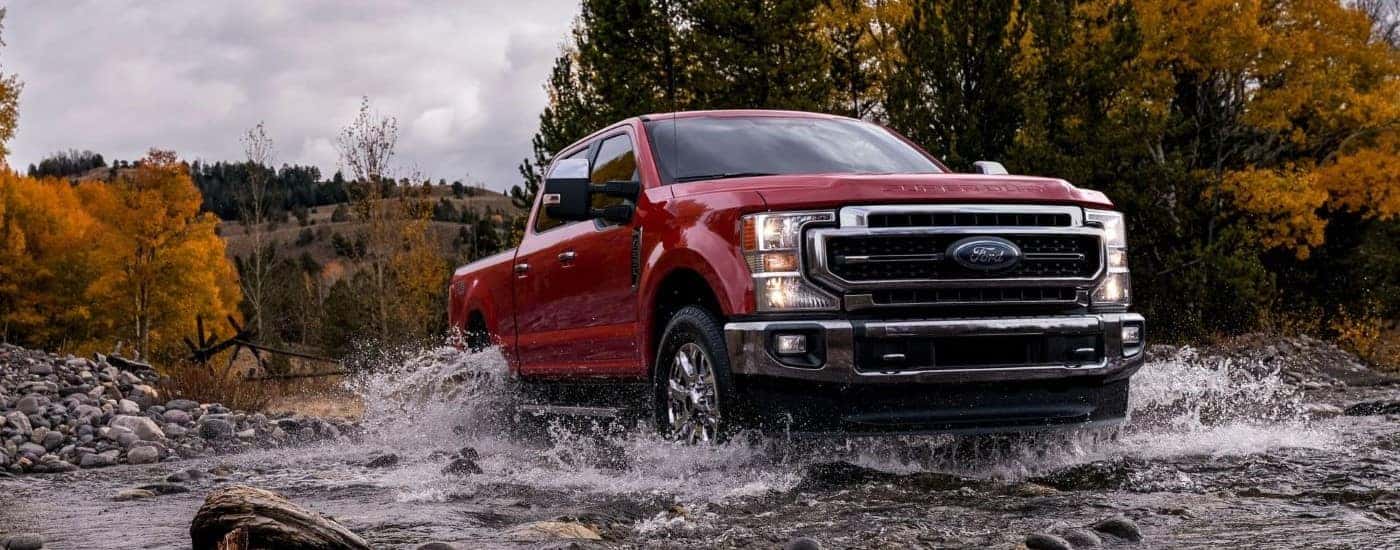 Red 2021 Ford F-250 crossing a creek