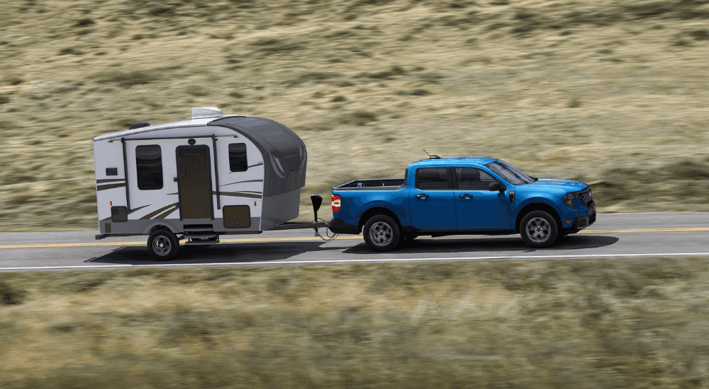 Blue 2025 Ford Maverick XLT towing a camper