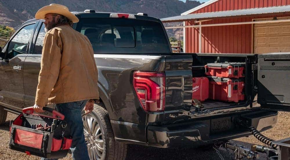 A person walking near the bed of a 2026 Ford F-150.