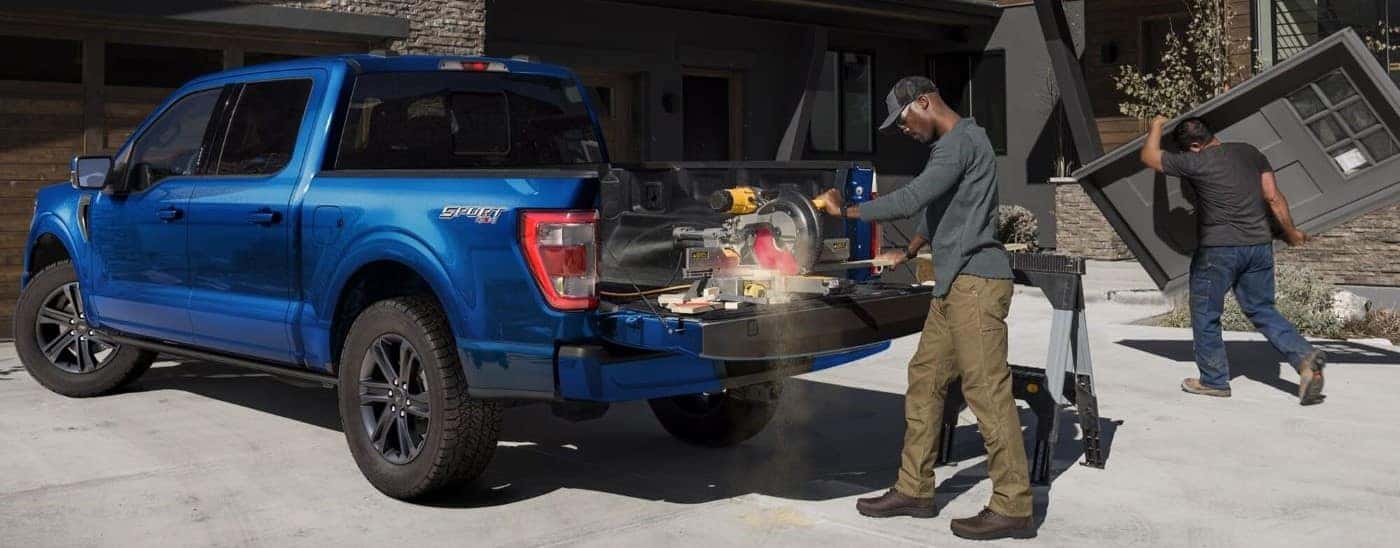 Man operating a power saw in the bed of a blue 2024 Ford F-150.