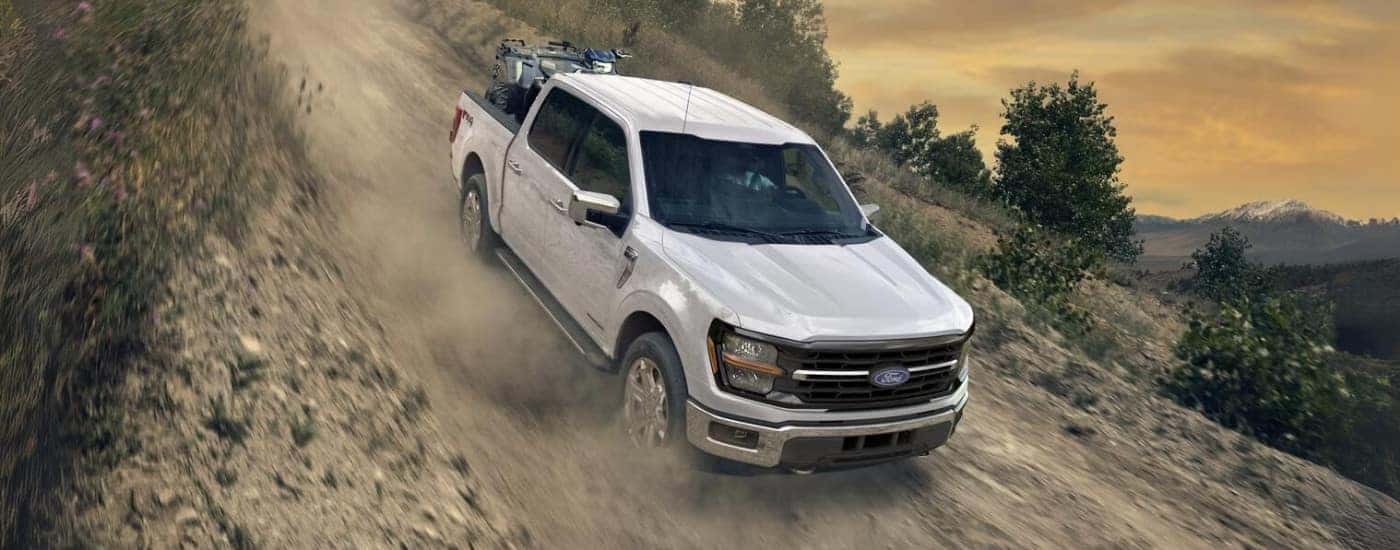 White 2025 Ford F-150 XLT driving down a hill.