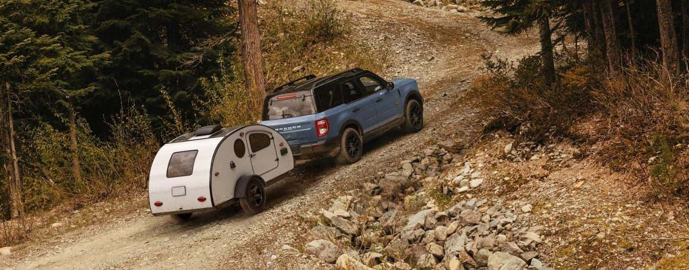 A blue 2026 Ford Bronco Sport towing a trailer uphill.
