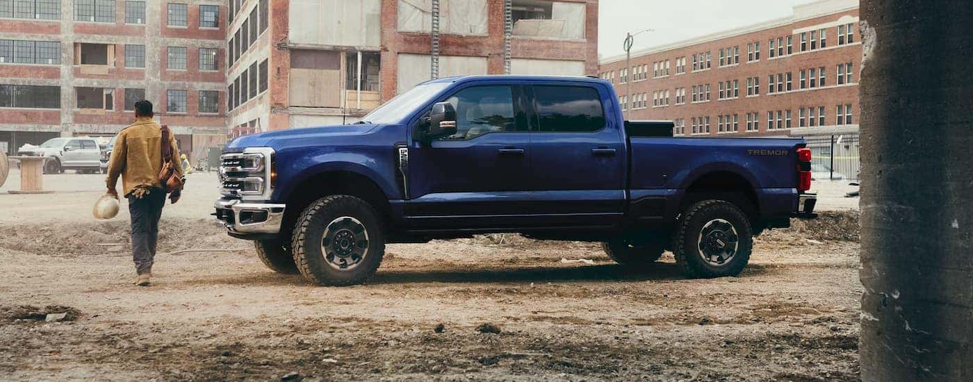 Side of a blue 2026 Ford F-350 Super Duty parked at a construction site.