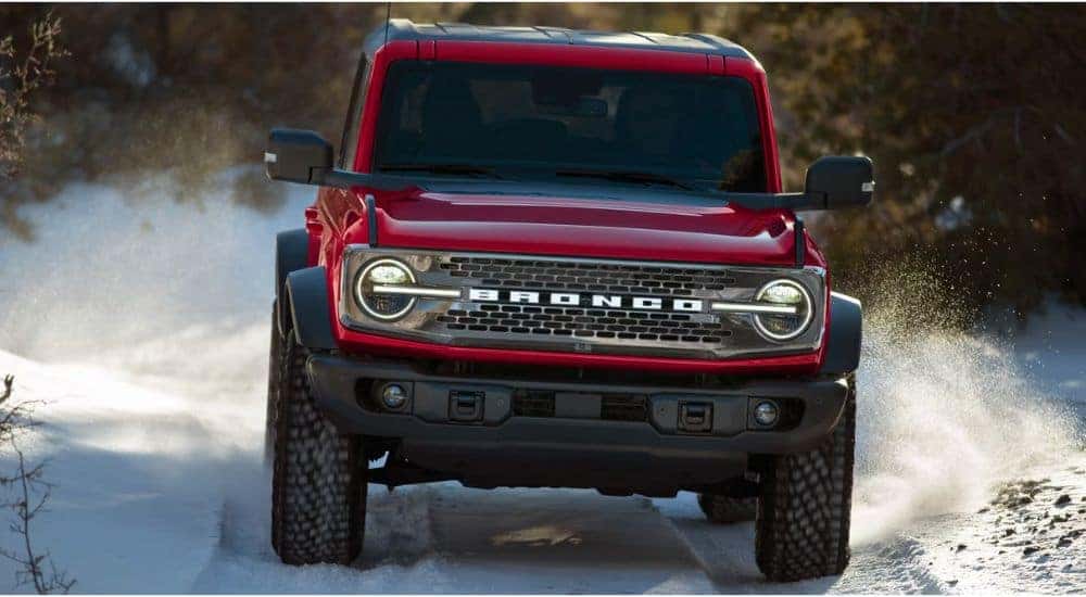 Red 2026 Ford Bronco driving through the snow